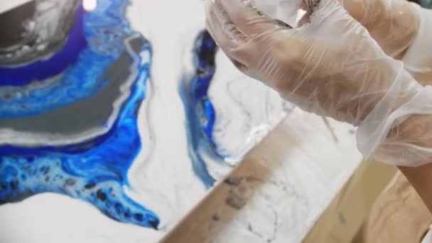 Diseño epoxi - verter resina epoxi blanca en la superficie de pintura de la taza de plástico — Vídeo de stock