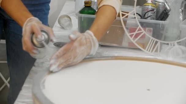 Zilveren verf spuiten op de ronde houten frames op het doek — Stockvideo