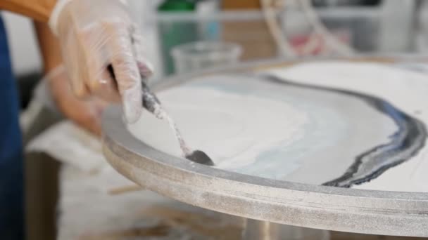 Untando resina epoxi blanca sobre pintura redonda usando una espátula — Vídeo de stock