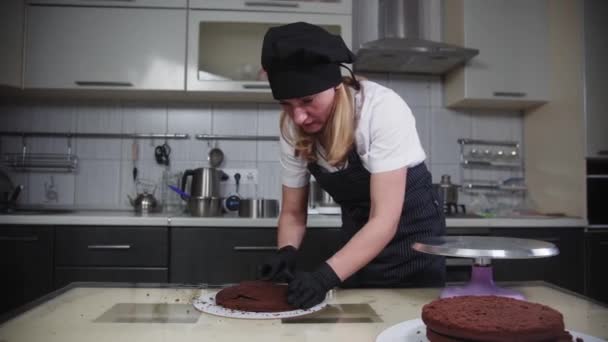 Ζαχαροπλαστική - μια γυναίκα ευθυγραμμίζει κέικ μπισκότων με την κοπή τους με ένα μαχαίρι — Αρχείο Βίντεο