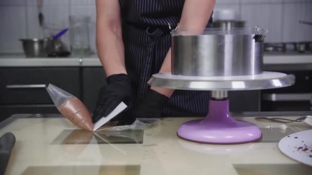 Cukrászda - egy nő csokoládé krémmel tölti meg a tésztazsákot — Stock videók