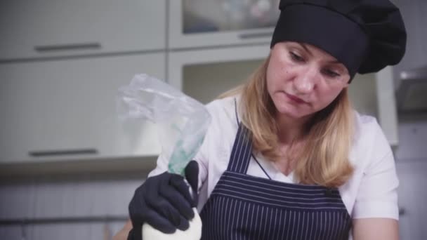 La confitería - la mujer pone la crema de vainilla a la base de la torta — Vídeo de stock
