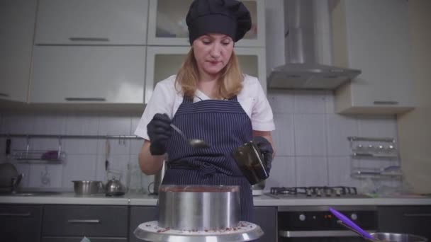 Ζαχαροπλαστική - μια γυναίκα απορροφά το κέικ σοκολάτας με σιρόπι — Αρχείο Βίντεο