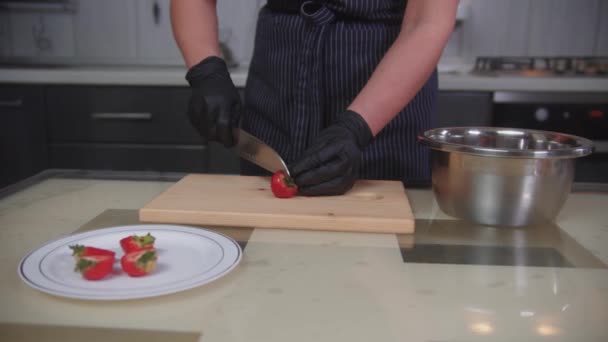 Cukrászda - cukrász darabolja az epret a torta díszítésére — Stock videók