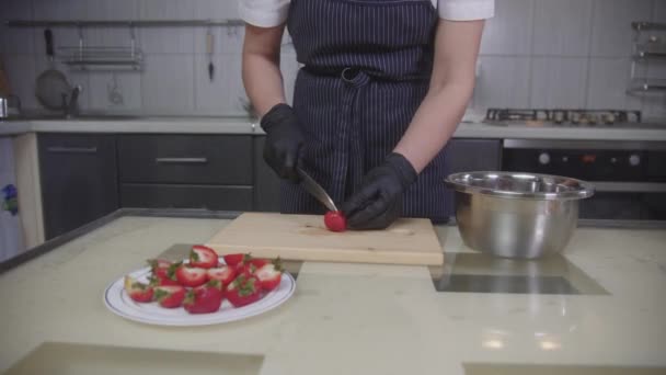 Confeitaria - chef de pastelaria corta morangos ao meio para decorar — Vídeo de Stock