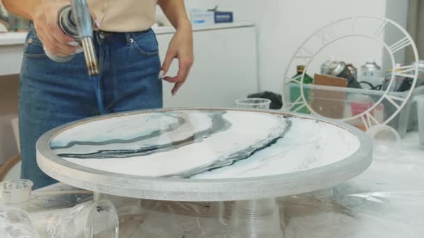 Mujer joven usando un quemador en la superficie de la pintura de resina epoxi — Vídeo de stock