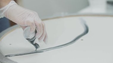 Yavaşça gri parıltılı epoksi reçine boyası dökerek yuvarlak yüzeye