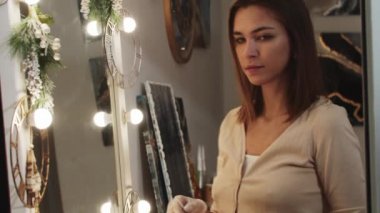 Sanat stüdyosunda epoksi reçinesini karıştıran genç bir kadın.