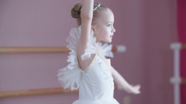 Entrenamiento de ballet - una niña en vestido blanco girando en el acto — Vídeos de Stock