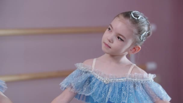 Ballet training - twee kleine meisjes in blauwe jurken die in positie staan en elkaar aankijken — Stockvideo