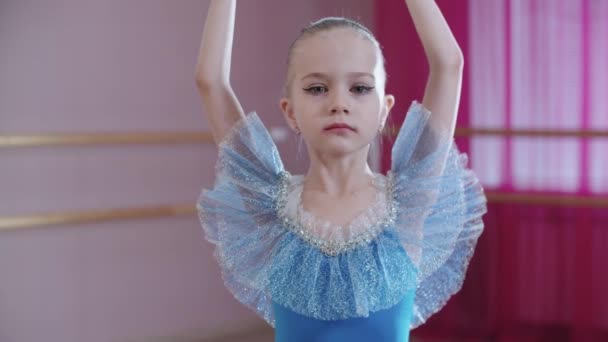 Bale eğitimi. Mavi elbiseli küçük bir kız olay yerinde dönüyor. — Stok video