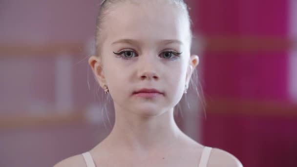 Mała dziewczynka balerina z jasnym makijażu spojrzenia w aparacie — Wideo stockowe