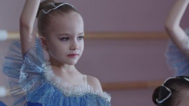 Bale eğitimi - mavi elbiseli dört balerin kız dans pozisyonunda duruyorlar.