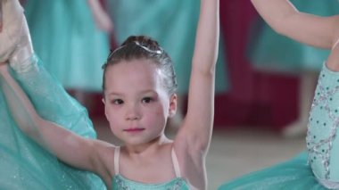 Bale eğitimi - iki küçük balerin kız bale dansı pozisyonunda duruyorlar.