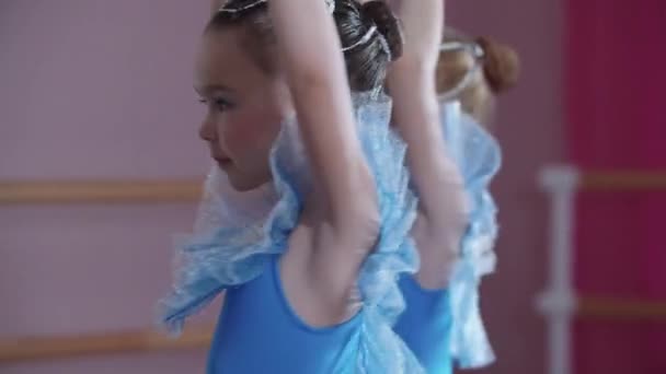 Balett utbildning - ballerina flickor i blå klänningar snurrar på plats i balett studio — Stockvideo