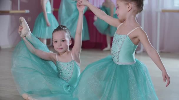 Entrenamiento de ballet - pequeñas bailarinas con vestidos azules entrenando en el estudio - dos de ellas de pie en posición de su danza de ballet — Vídeos de Stock