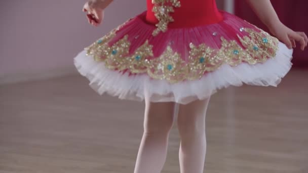 Entrenamiento de ballet - una niña en vestido rojo que muestra una posición de ballet — Vídeos de Stock