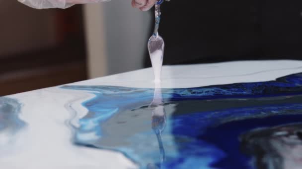 Applying details with white epoxy on the painting using a spatula — Stock Video