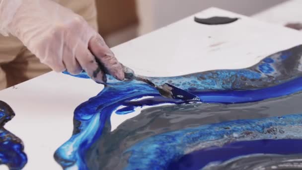 Ayrıntıları spatula kullanarak resmin üzerine koyu mavi epoksi ile uygulamak — Stok video