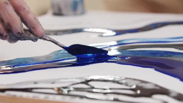 Aplicando resina epóxi azul escuro na pintura usando uma espátula — Vídeo de Stock