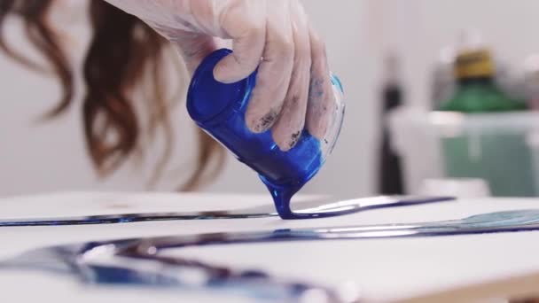 Verse de la résine époxy bleu profond sur toile à partir d'un récipient en plastique — Video