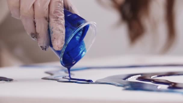 Artista vierte resina epoxi azul profundo sobre lienzo de una taza de plástico — Vídeo de stock