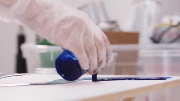 Sanatçı tuval üzerine koyu mavi epoksi reçine döker — Stok video