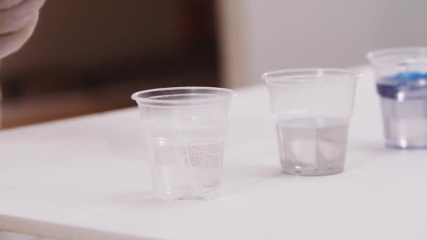 Художник змішування білої епоксидної смоли в пластиковій чашці — стокове відео