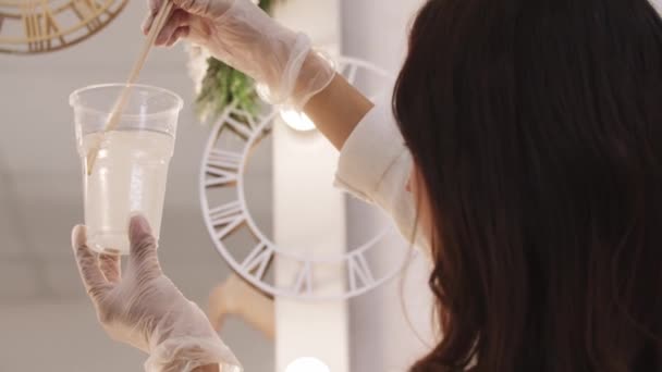 Sanatçı büyük plastik bir bardakta epoksi reçinesinin şeffaf bir tabanını yoğurur — Stok video