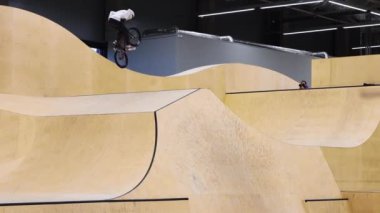 BMX sporları. Antrenman sahasında rampalarda at süren genç bir adam.