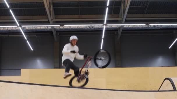 Deportes BMX - joven montando haciendo truco complejo en su bicicleta — Vídeos de Stock