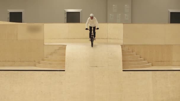 Deportes BMX - joven montando por la rampa y realizando un truco — Vídeos de Stock