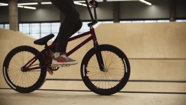 Deportes BMX: el joven se sienta en su bicicleta deportiva y comienza a montar en rampas — Vídeos de Stock