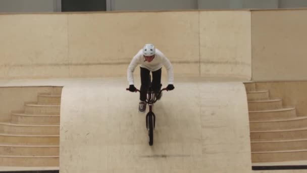 Joven monta en bicicleta por la rampa y cae en la piscina en esponjas — Vídeos de Stock