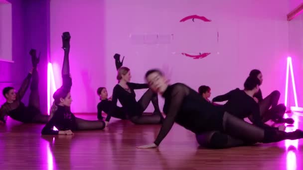 Un groupe de danseuses s'étirant dans le studio portant des talons hauts et des vêtements noirs — Video