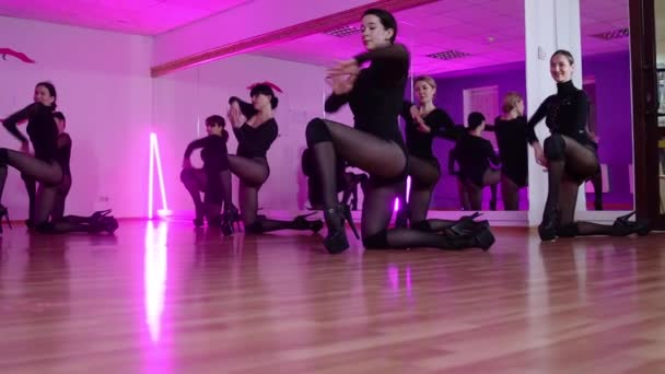Grupo de mujeres en ropa negra bailando y twerking en estudio con iluminación púrpura — Vídeo de stock