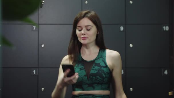 Νεαρή όμορφη γυναίκα παίρνει μια selfie σε σπορ κοστούμι στα αποδυτήρια — Αρχείο Βίντεο