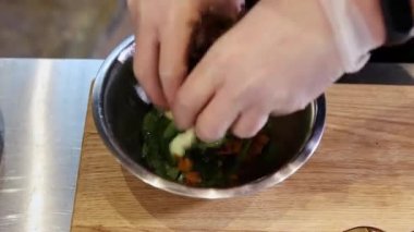 Şef tabağında salata olan balık parçaları servis ediyor.