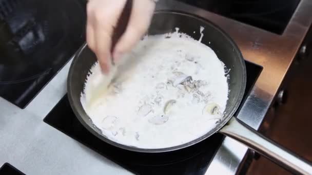 Un chef prepara pasta con champiñones en una sartén — Vídeos de Stock