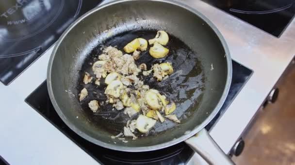 Шеф-повар готовит макароны с грибами на сковородке — стоковое видео