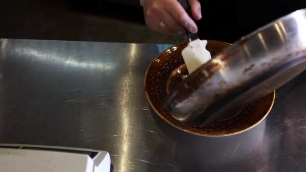 Kokken spreder cremet pasta med svampe fra panden på en tallerken – Stock-video