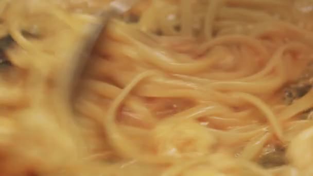 Chef revuelve los espaguetis en una sartén — Vídeos de Stock
