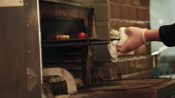 Restaurang matlagning - kocken tar ut en bit kött från ugnen — Stockvideo