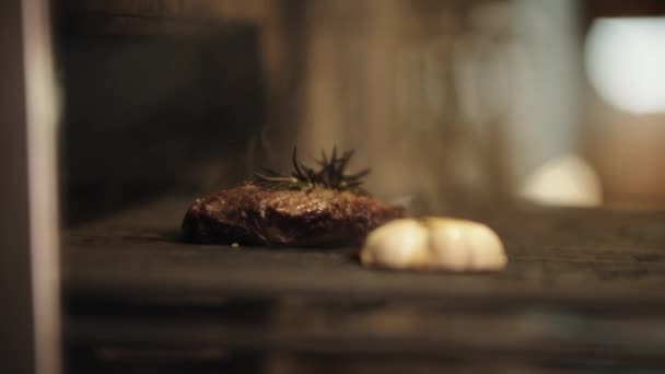 Cozinha de restaurante - o chef tira um pedaço de carne com alecrim do forno — Vídeo de Stock