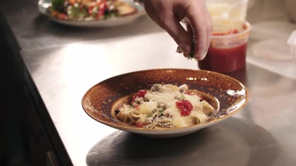 Restaurang matlagning - kock strössel örter och ost på pasta — Stockvideo