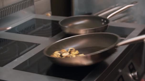 Ресторан приготовления пищи - шеф-повар жарит грибы на сковородке — стоковое видео