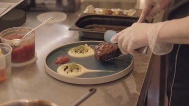 Restoran yemekleri. Şef, yanında kremalı bir tabak et servis ediyor.