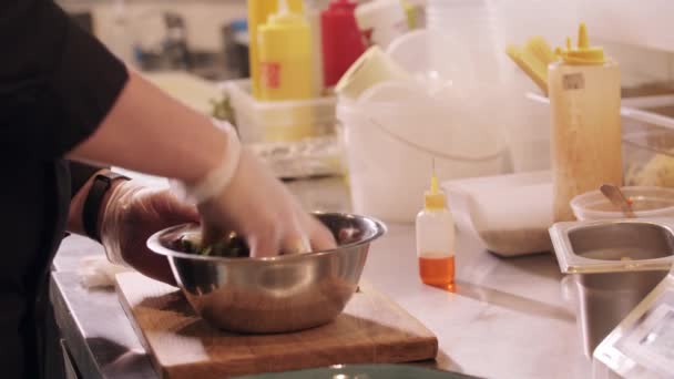 Éttermi főzés - szakács keveri saláta levelek olajjal egy tálban — Stock videók