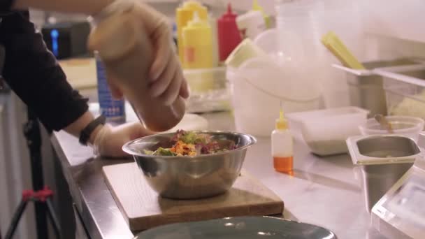 Cozinha de restaurante - chef acrescenta molho a uma salada de abóbora — Vídeo de Stock