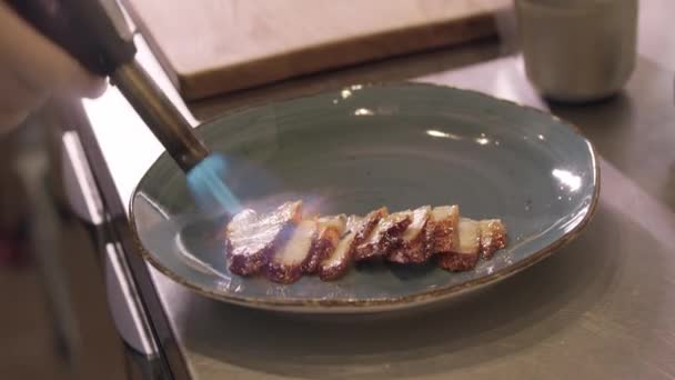 Cocina de restaurante - chef quema rebanadas de pescado con un quemador — Vídeos de Stock